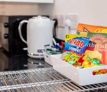 A close up of the tea and coffee making facilities at The Loft Penthoose, as well as a selection of biscuits and sweets