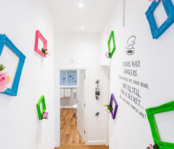 A hallway with colourful frames and writing on the wall